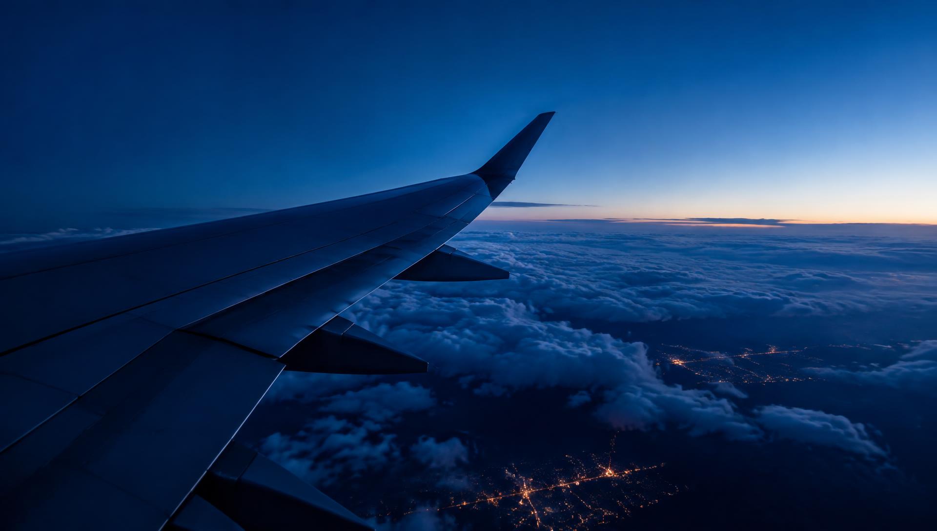 Aircraft wing above clouds at dusk